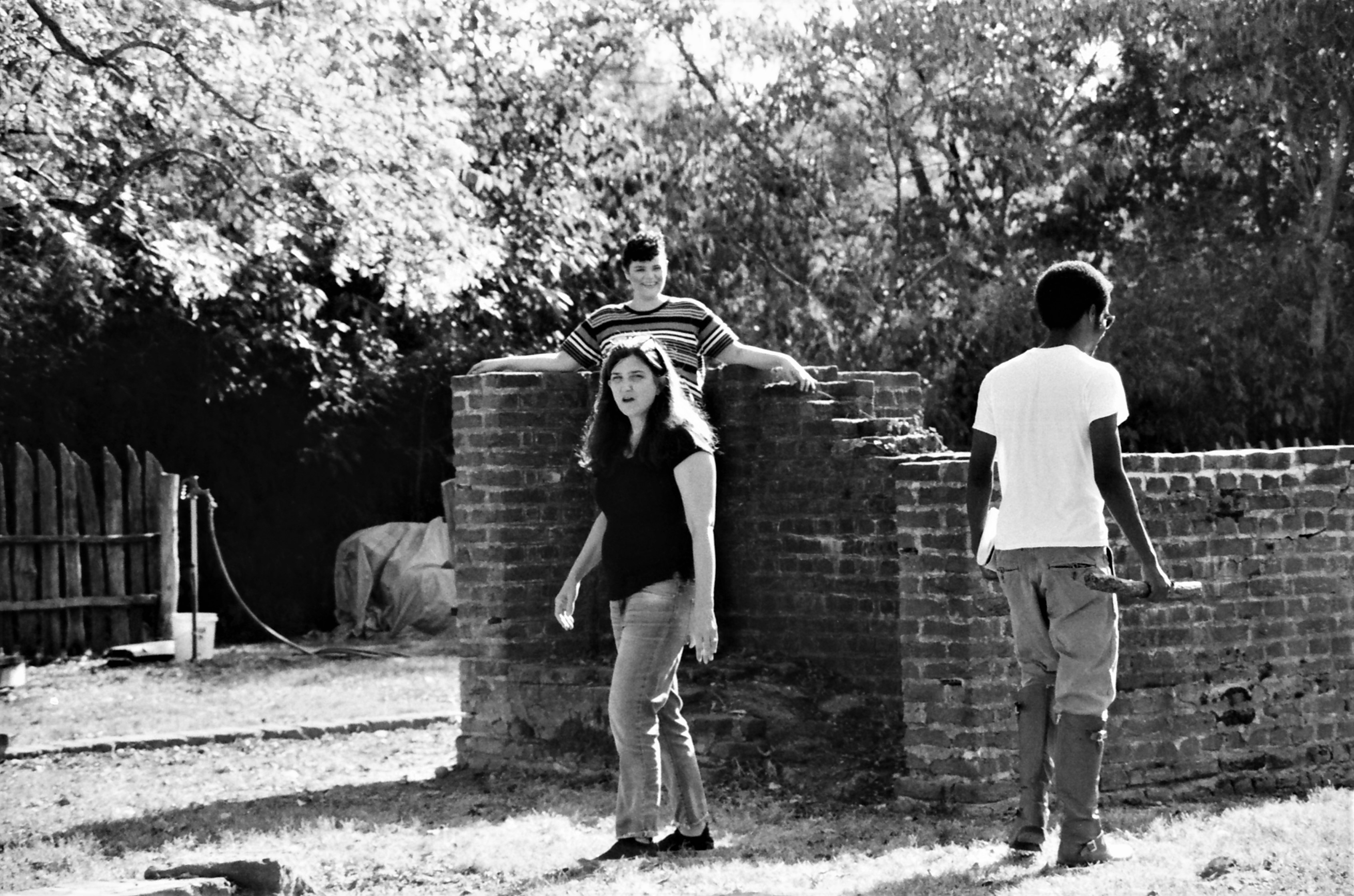 A person directing outdoors surrounded by two student actors. Photo credit Chloe Colvin.