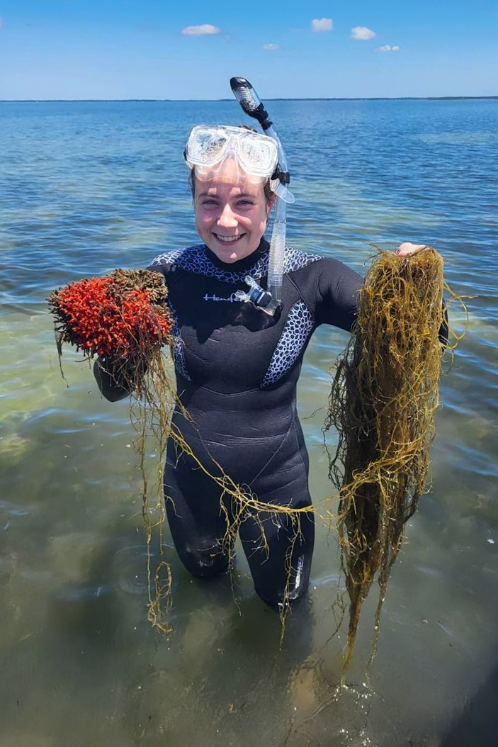 Photo of a student intern holding seagrass