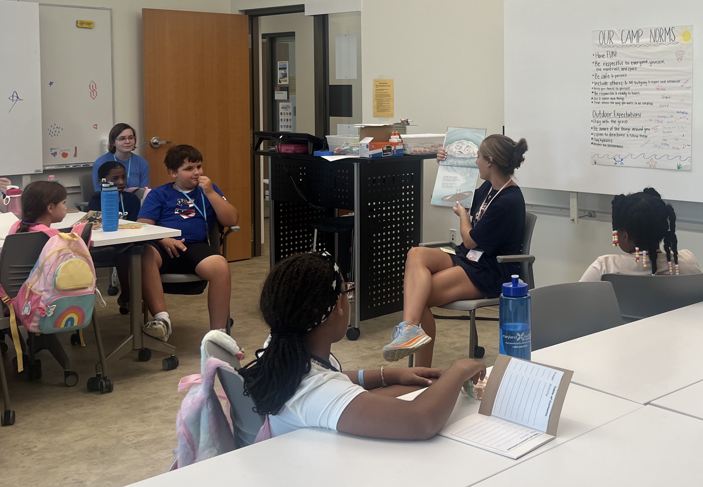 教育研究 students read aloud to students in a classroom.