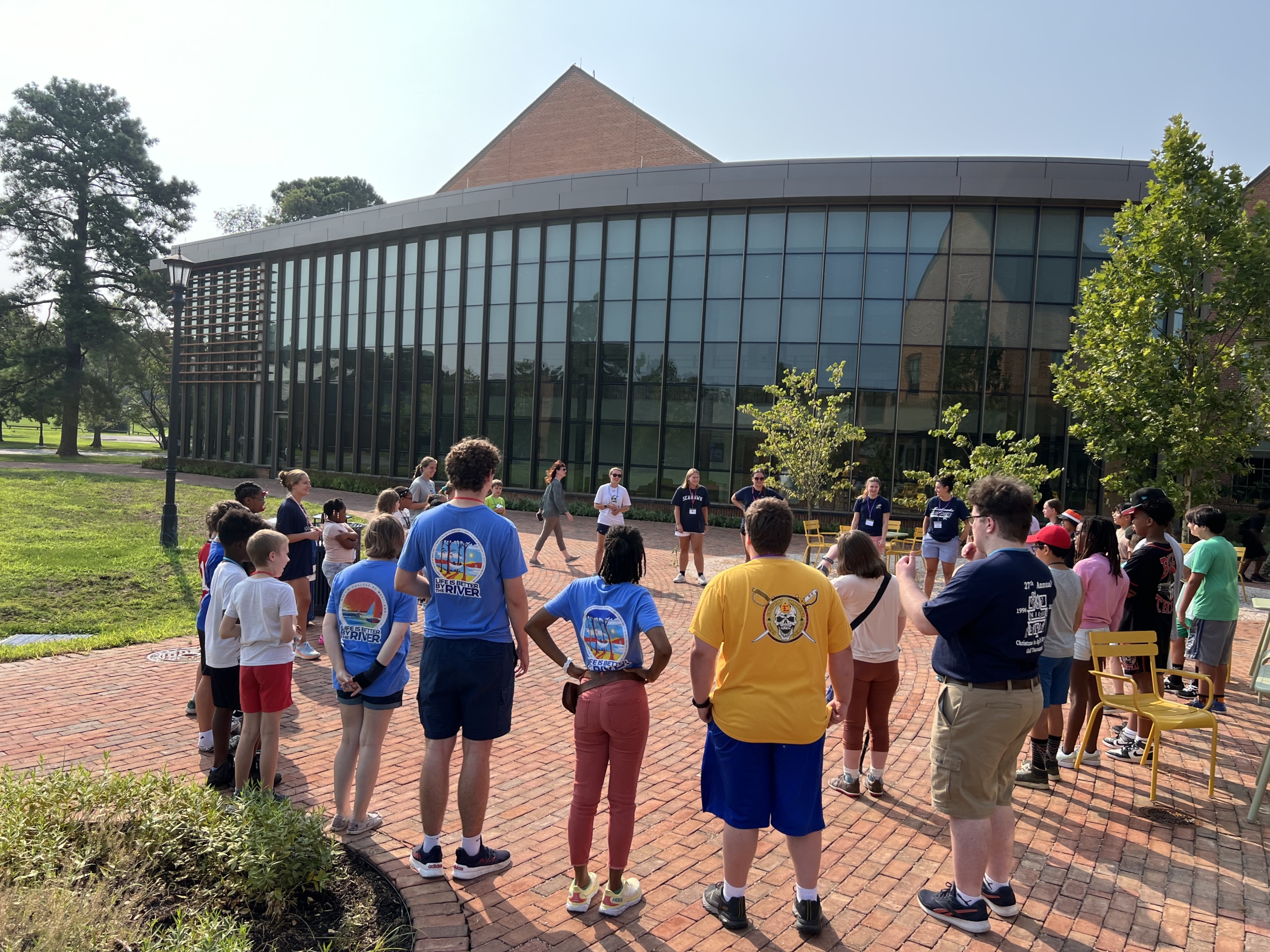 Educational studies students leading a group of elementary students in a circle in front of the 学习共享
