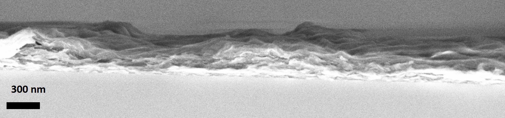 Cross-sectional scanning electron microscope (SEM) image showing a layered material structure with a scale bar indicating 300 nm.