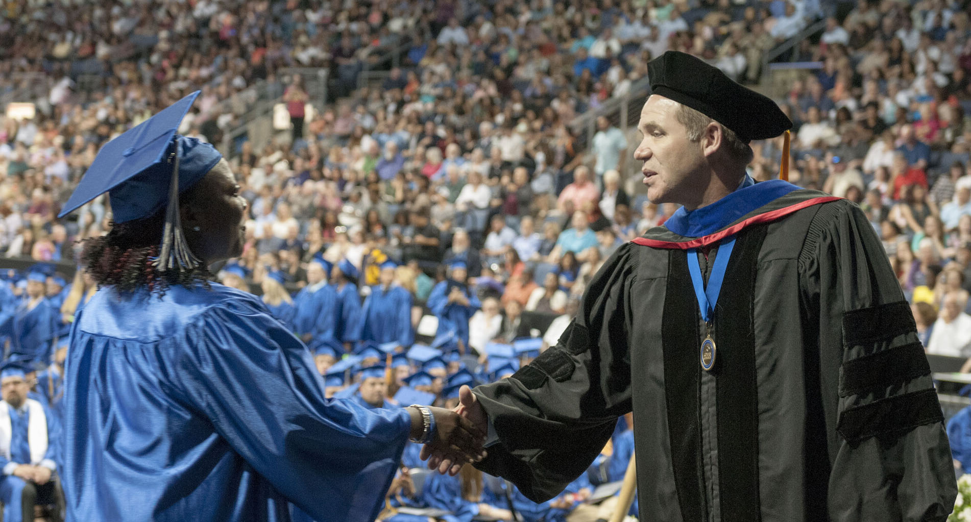 Collin College Trustee Jim Orr congratulates a graduate at the 2017 commencement.