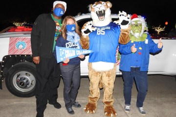 皇冠体育平台参加了法默斯维尔的年度圣诞游行, staff posing with Collin Cougar mascot.